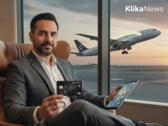 Estrategia Aérea 2026: ¿Qué tarjeta maximiza tus viajes y privilegios?. Ejecutivo utilizando tarjeta de crédito premium en sala VIP de aeropuerto con avión al fondo.